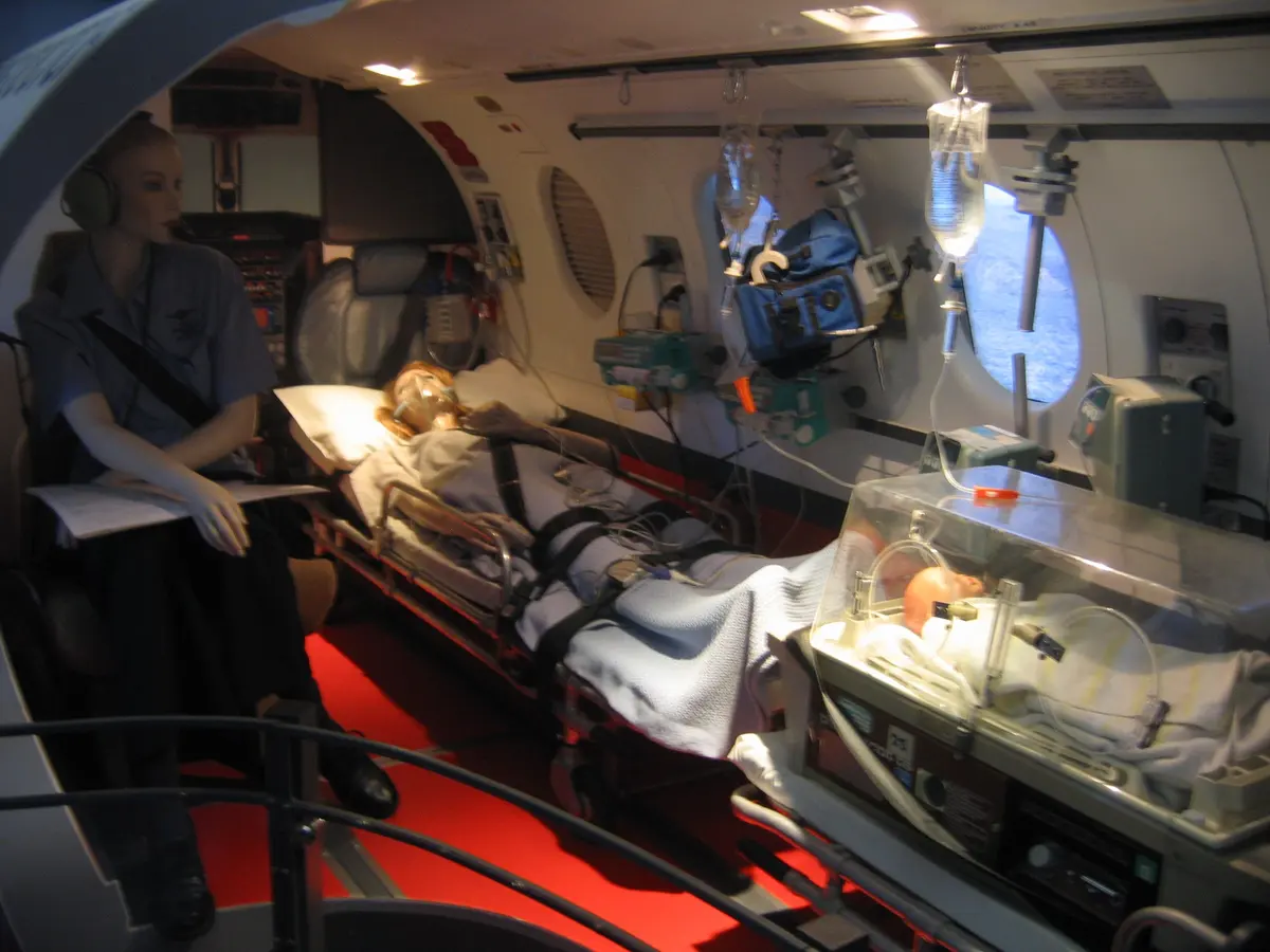 Cabine d'avion sanitaire aménagée : patient sur civière et équipement médical