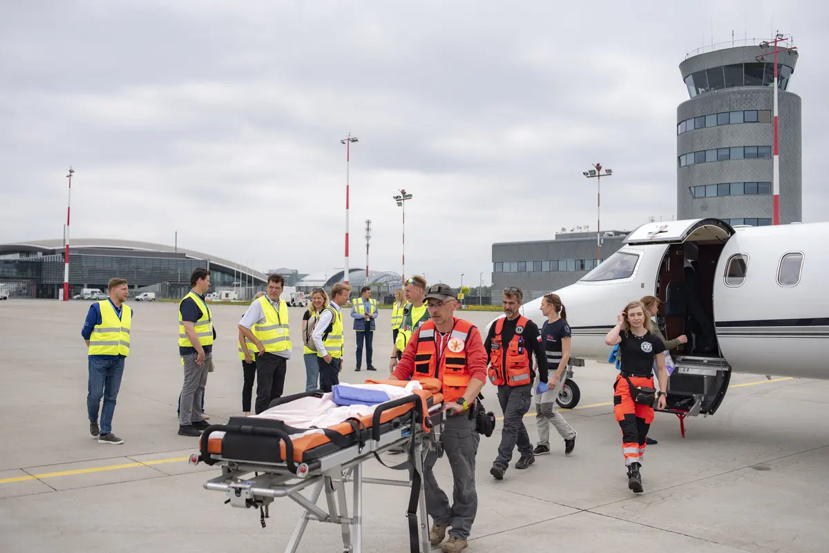 Équipe de secours avec civière rejoignant un avion sanitaire